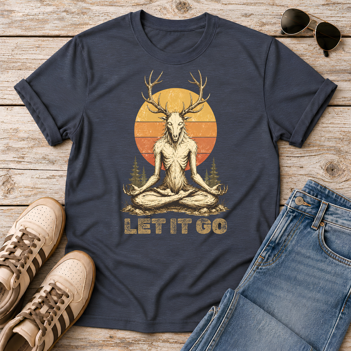 Shop the Meditating Wendigo Graphic T‑Shirt, featuring an antlered forest spirit meditating beneath a retro sunset. Perfect for cryptid fans, folklore lovers, and forest weirdos. 🦌🔮