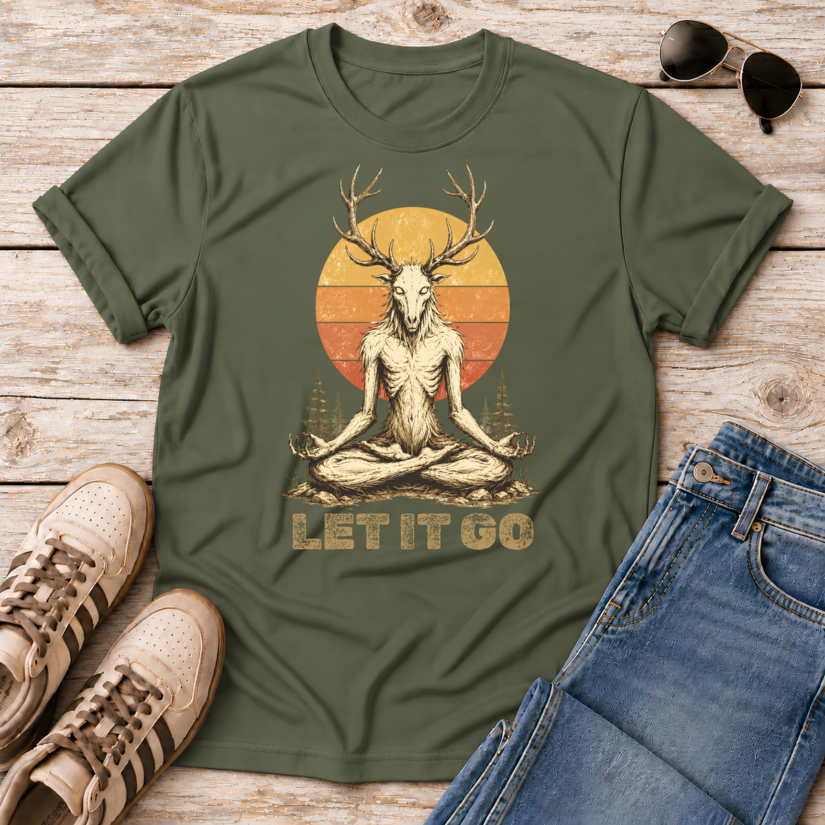 Shop the Meditating Wendigo Graphic T‑Shirt, featuring an antlered forest spirit meditating beneath a retro sunset. Perfect for cryptid fans, folklore lovers, and forest weirdos. 🦌🔮